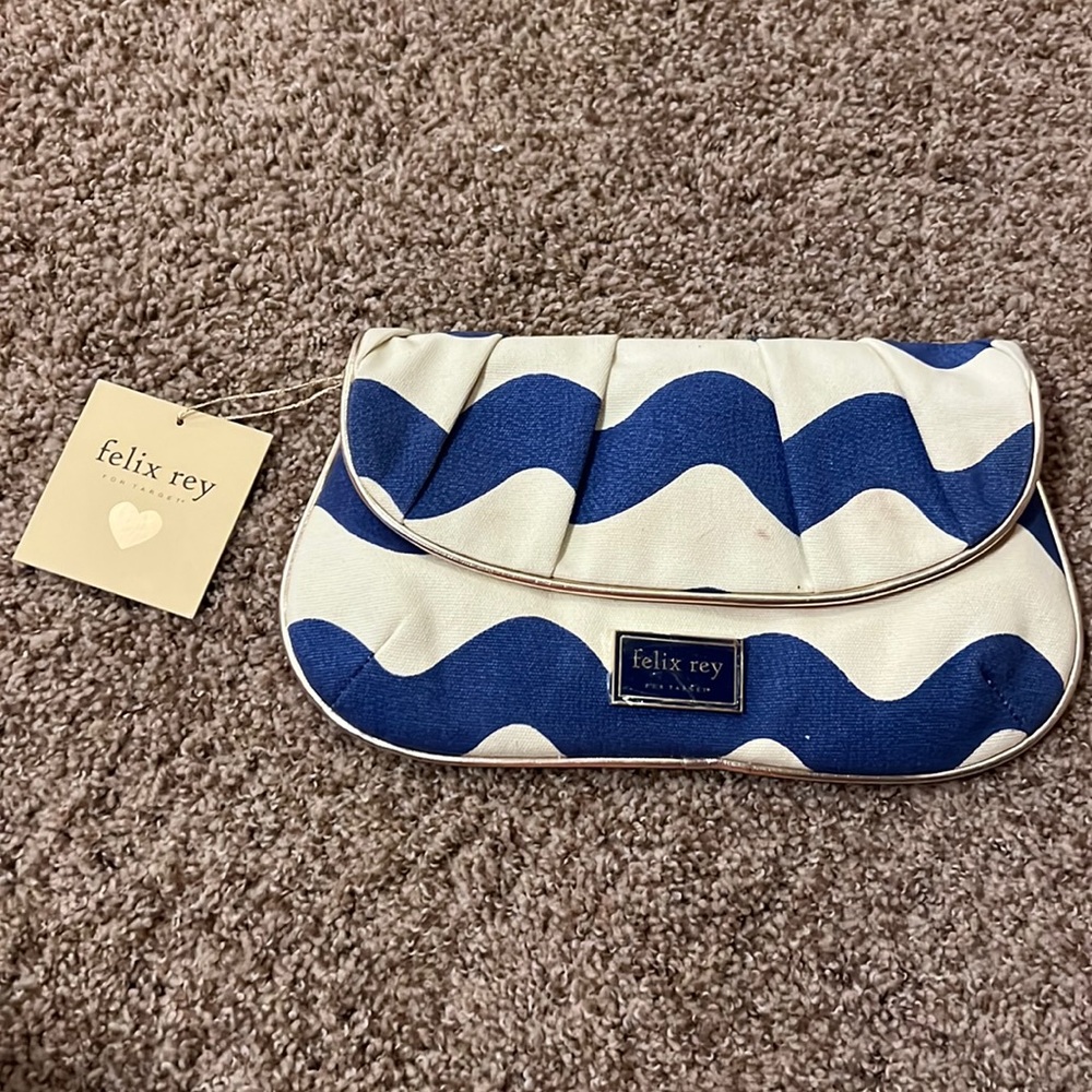 Small fabric clutch with faux leather piping